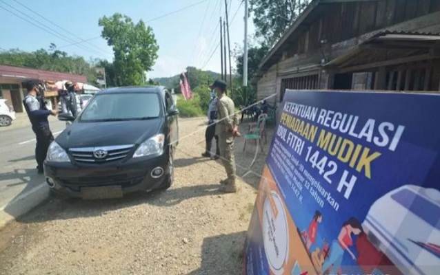 Petugas memberhentikan kendaraan dari arah Riau saat mellintas di Posko Penyekatan